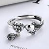 Close up of a silver ring with a koi fish and lotus flower design