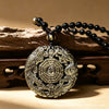 Round Golden Obsidian pendant with carved dragon and phoenix on a black bead necklace