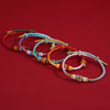 Colorful gradient braided bracelets with gold-tone beads on a red background