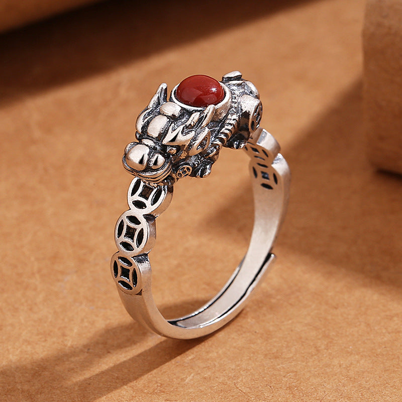 Close up of a silver-tone copper ring featuring a Pixiu head and a red stone