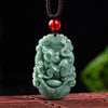 Green carved jade pendant with red bead on brown cord