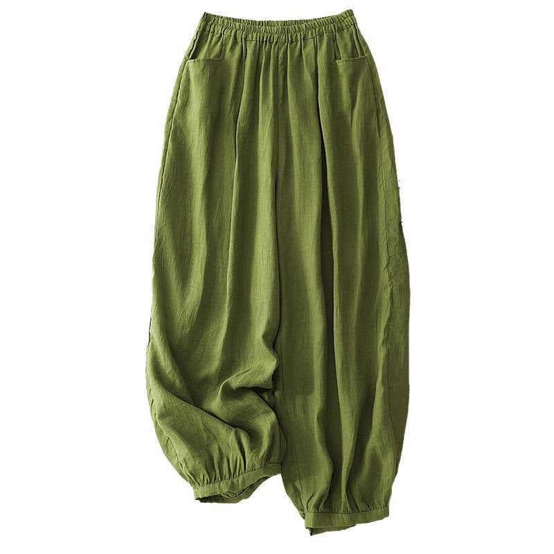 Four pairs of women's cotton slub pants in green, white, grey, and pink laid flat on a beige surface.