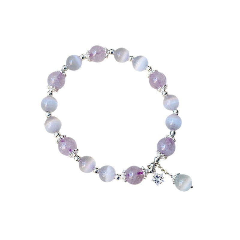 Purple amethyst and cat's eye bead bracelet with a silver star charm on a wrist