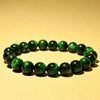 Green and blue tiger eye beaded bracelets on a yellow background