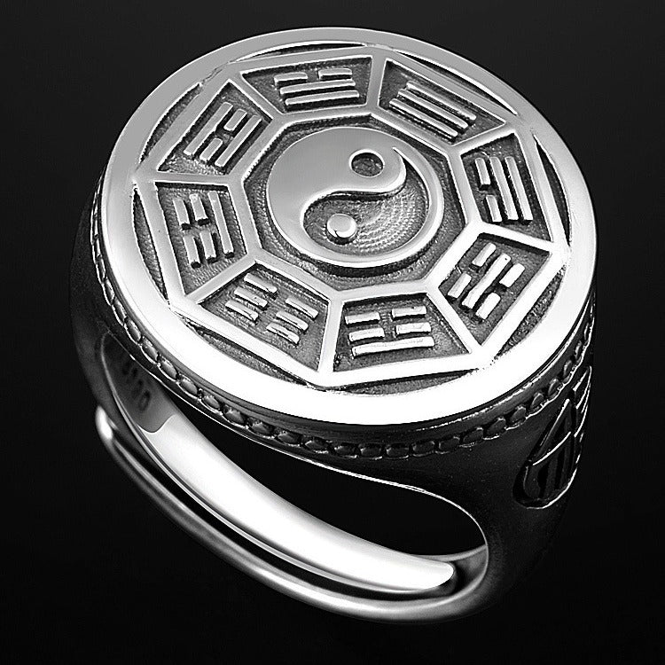 Close up of a silver tone adjustable ring with a round face showing the Bagua trigrams and Yin Yang symbol