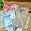 Four folded floral print sleeveless tops in pink, beige, blue, and green