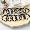 A collection of dark blue woven bracelets with silver cube charms showing zodiac symbols