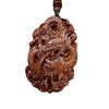 Close up of carved wooden pendant with two dragons on a brown cord