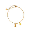 Gold-tone chain anklet with a small gourd charm worn on an ankle