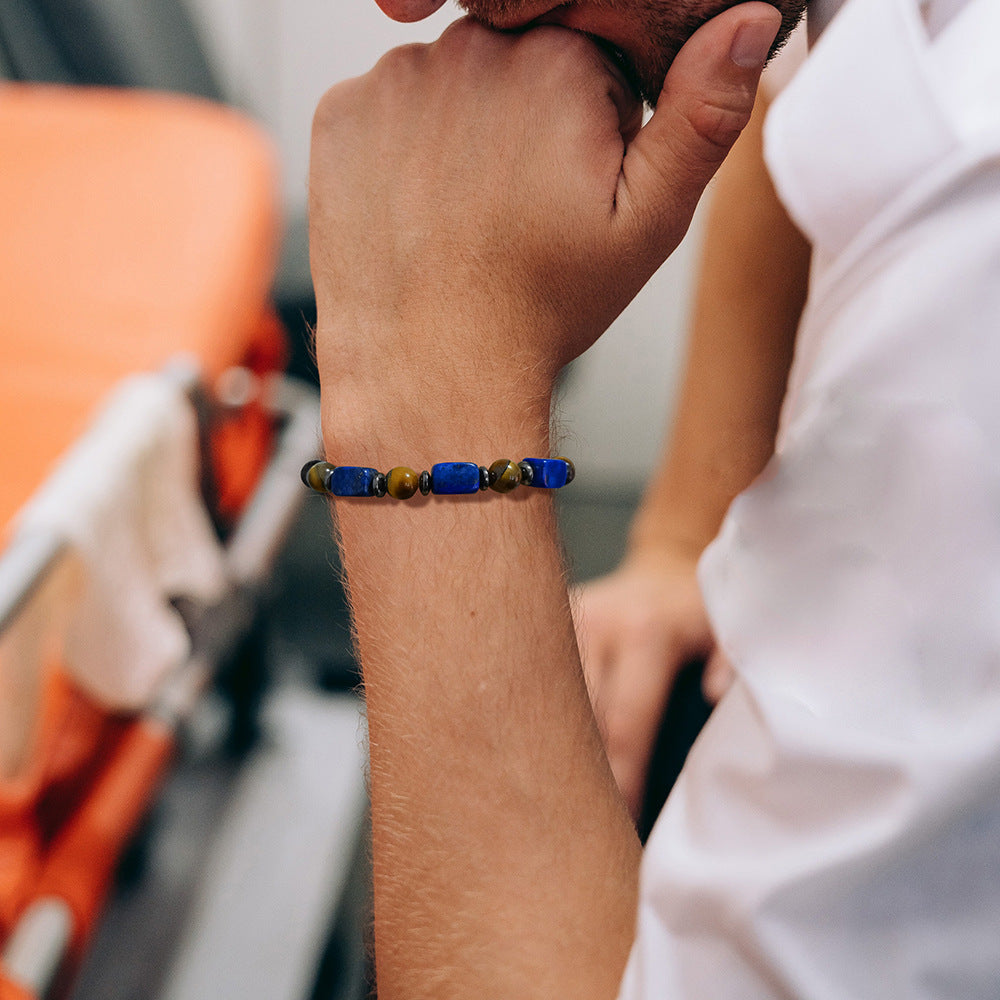 Man wearing a stretch bracelet with square blue stones and brown tiger eye beads