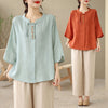 Woman wearing a light green cotton linen shirt with beige wide leg pants