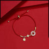 Woman wearing a red string bracelet with a white jade peace buckle charm against a red background