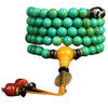 Coiled green turquoise mala with black and gold eye beads on dark fabric