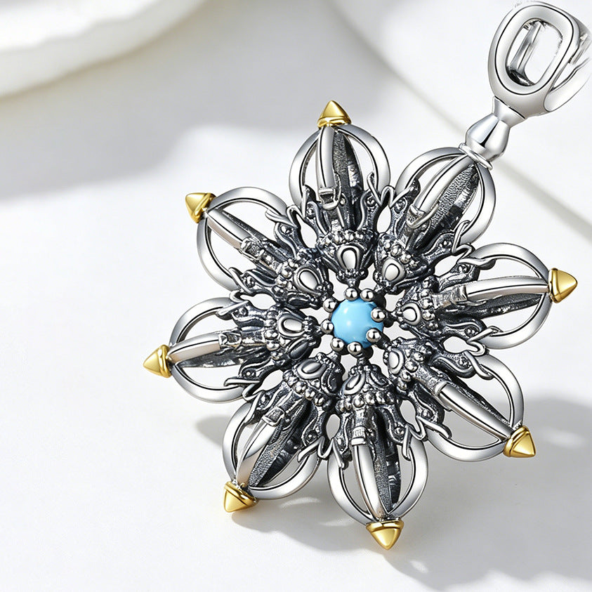 Close up of silver plated copper lotus vajra pendant with blue center stone