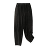 Black corduroy women's harem pants with elastic waist displayed against white background