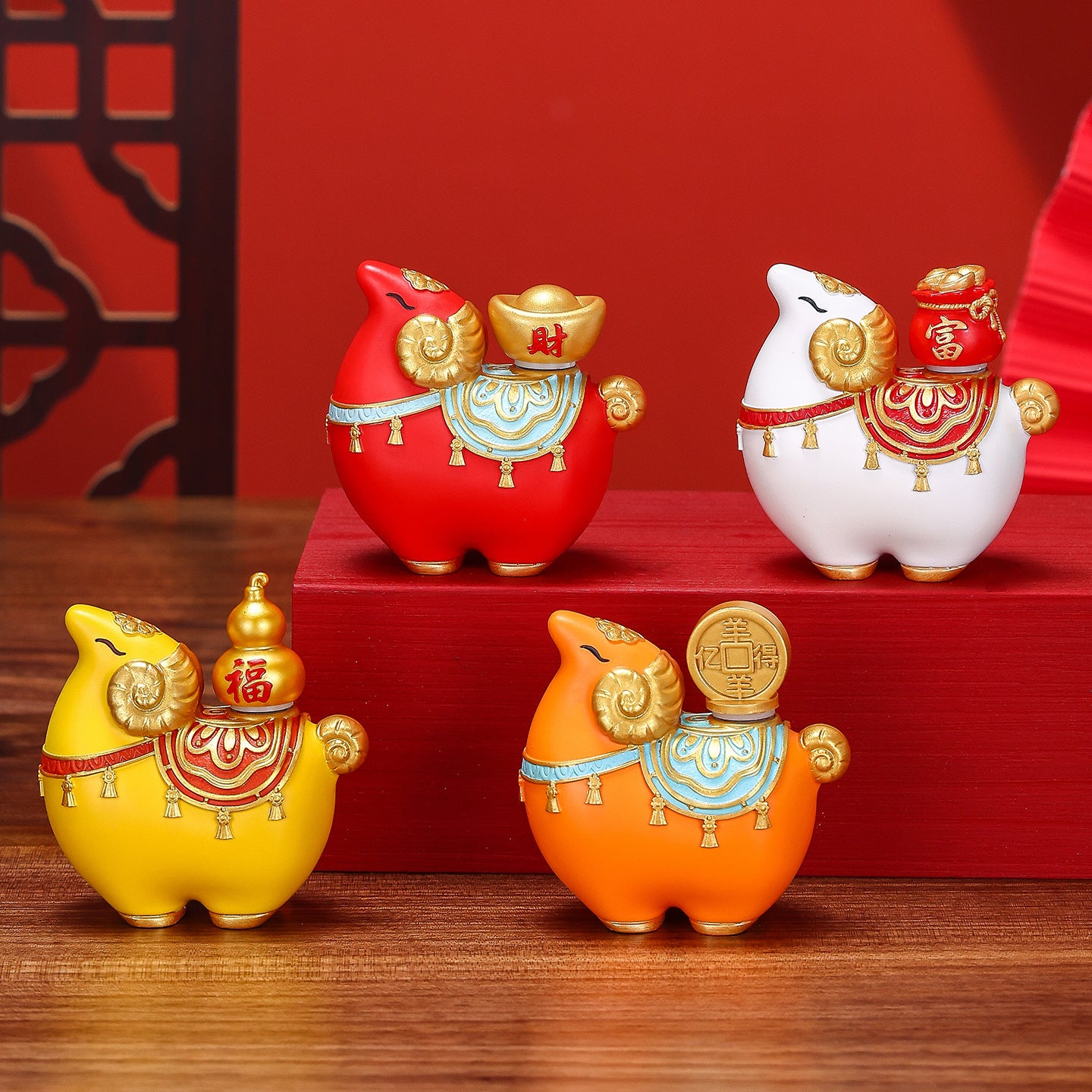Four colorful resin goat figurines sitting on a wooden surface