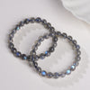 Polished moonstone beads bracelet with blue flash on white background