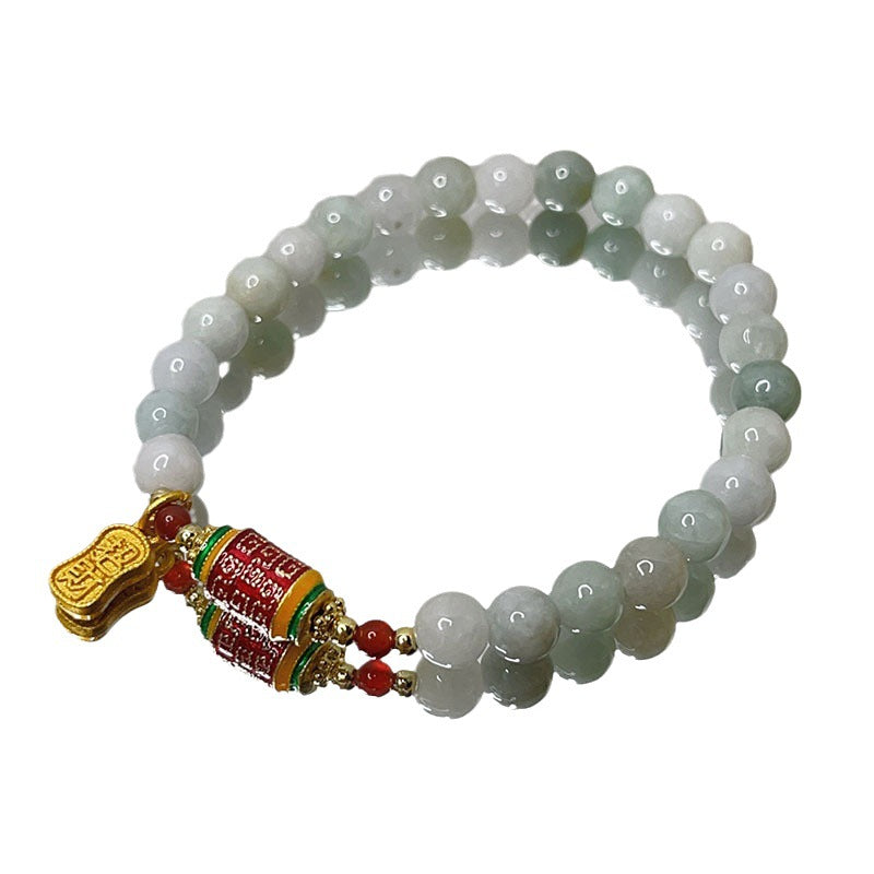 Jade beaded bracelet with red prayer wheel and gold charm