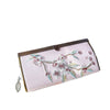 Close-up of a pink velvet wallet with white and green floral embroidery and a metal clasp