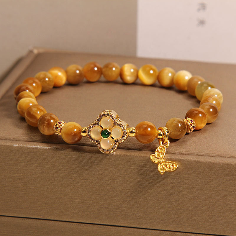 Golden tiger eye beaded bracelet with a four-leaf clover center and butterfly charm