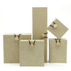 Stack of beige linen-textured jewelry boxes with wood button closures