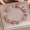 Close up view of pink strawberry quartz and colorful crystal beads on a bracelet