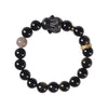 Close up of a black beaded bracelet with a carved rabbit charm on a wrist