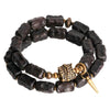 Double wrap bracelet with dark textured beads and gold tone vajra charm on wrist