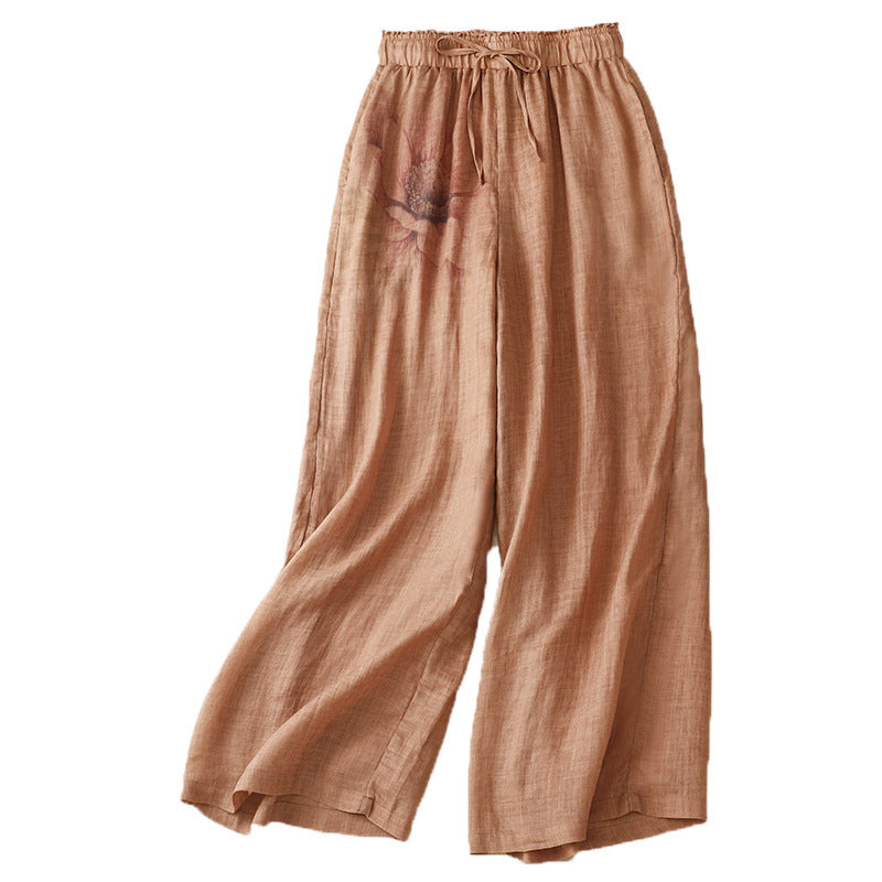 Three pairs of wide leg cotton linen pants in grey, white, and orange laid flat showing floral print details