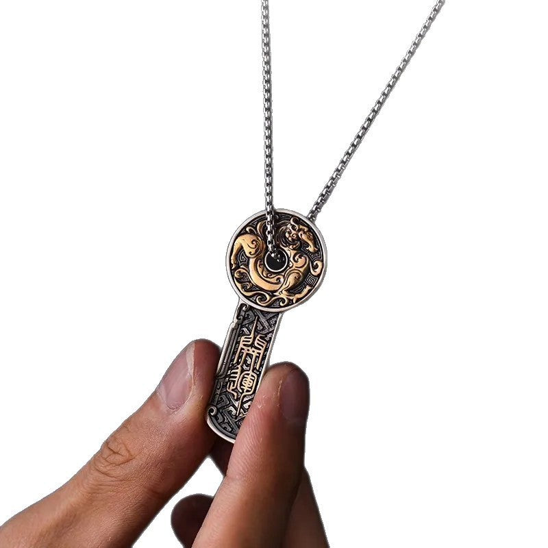 Close-up of a copper dragon coin pendant necklace held against a white background