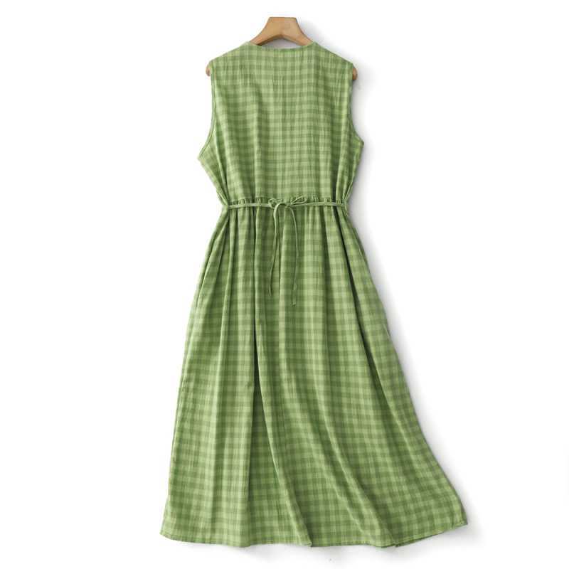 Green plaid sleeveless cotton dress hanging on a wooden hanger