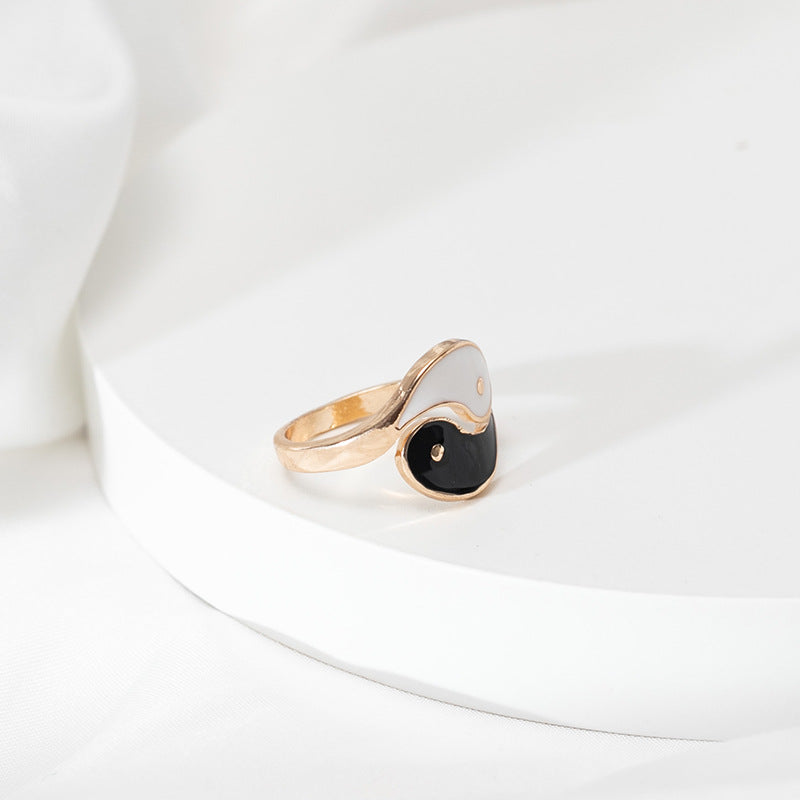 Gold-tone open ring with black and white Yin Yang enamel design on a finger