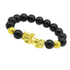 Gold-tone Pixiu charm on a black beaded bracelet against a dark background