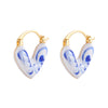 Close up of blue and white porcelain heart shaped hoop earring on ear