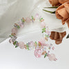 Pink faux crystal bracelet with flower and fox charms on white fabric
