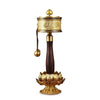 Close up of a gold tone Tibetan prayer wheel with intricate engravings