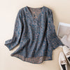 Flat lay of a dark blue women's V-neck shirt with a brown floral print and three-quarter sleeves