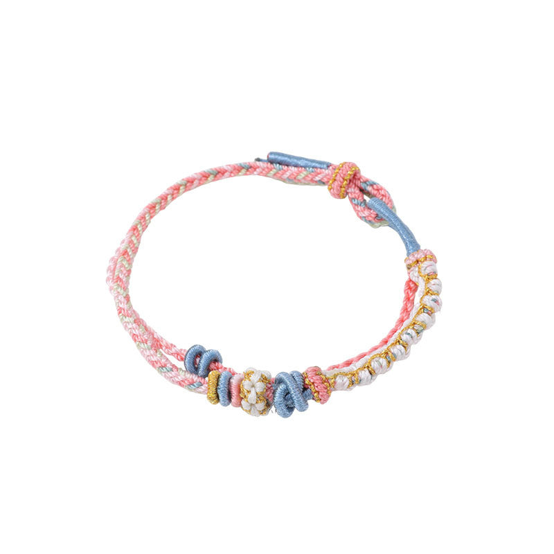 Close up view of a multi-colored hand-woven double layer string bracelet with knot details