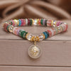 Close-up of a colorful crystal bracelet with a white peace buckle charm