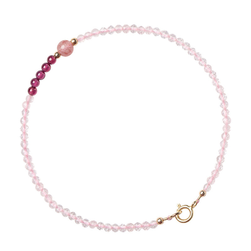 Close-up of a wrist wearing a thin pink and red beaded bracelet with a gold clasp