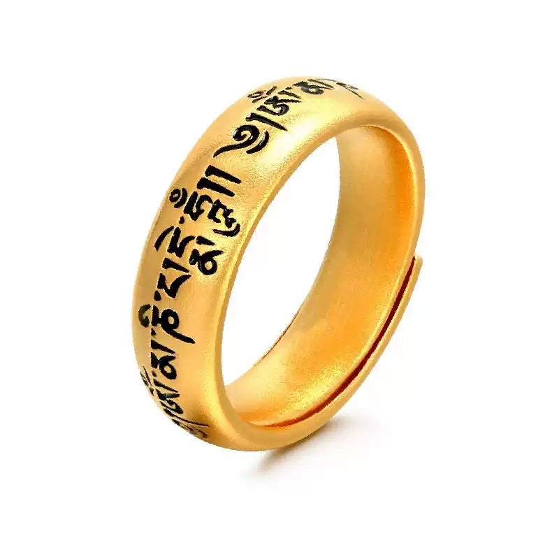 Close up of gold tone adjustable ring with Tibetan script engraving