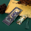 Gold tone metal bookmark with green tassel on a book
