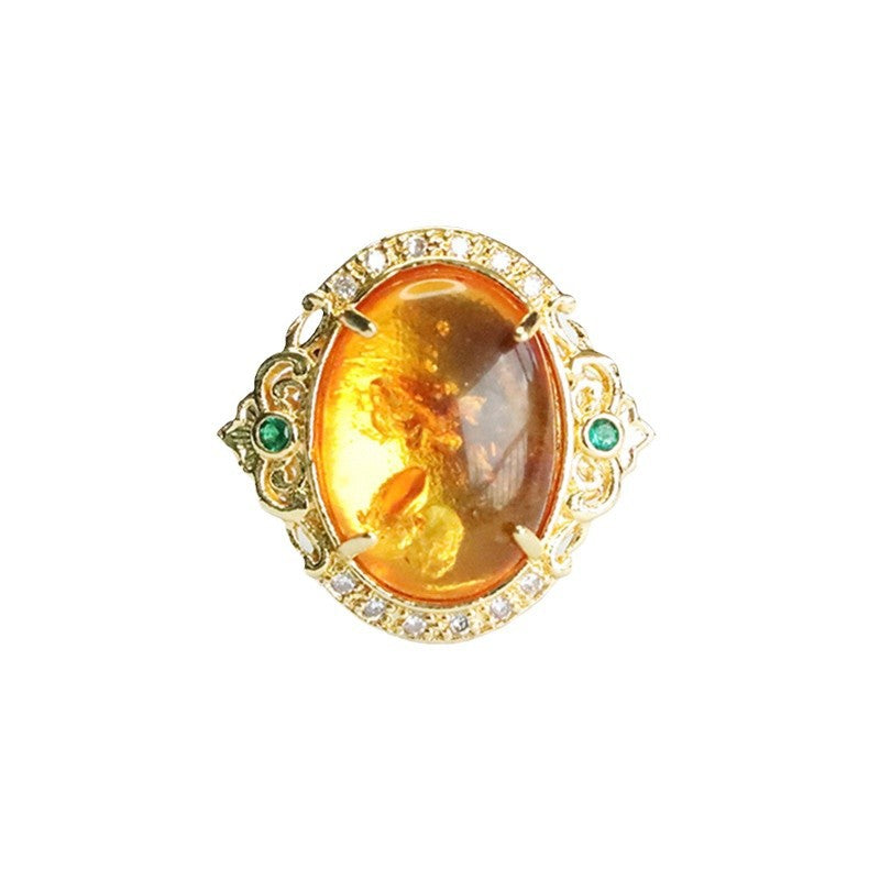 Close-up of a vintage ring with an oval of flower amber in a gold-plated setting