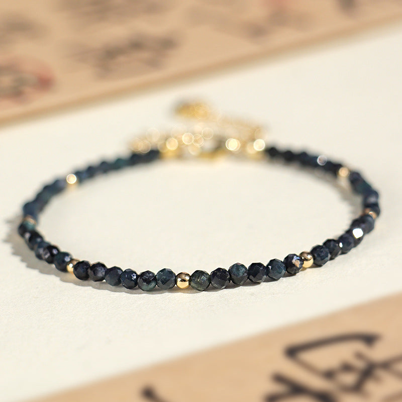 Close up of a blue tourmaline beaded bracelet with gold spacers