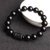 Close up of black obsidian bracelet with carved dragon detail