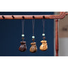 Three wooden money bag pendants hanging from a wooden rack
