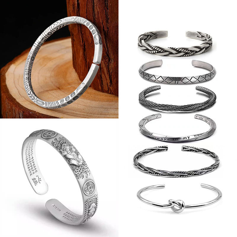Close up of a silver tone twisted braided open cuff bracelet on a wooden surface