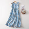 Blue and white gingham sleeveless dress hanging on a wooden hanger
