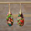 Pair of multicolor Emperor Stone teardrop earrings hanging from a gold rod