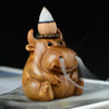 Close up of a wooden calf shaped incense burner with smoke flowing from its nostrils